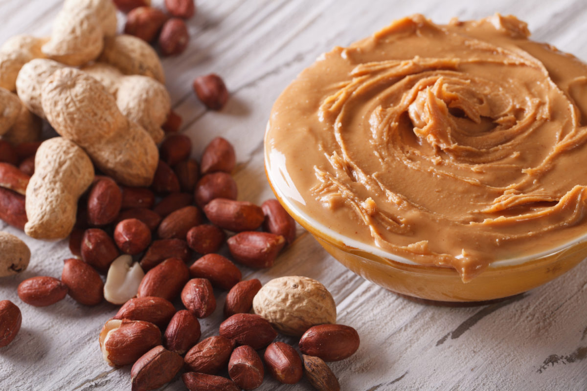 Peanut cream in a bowl close up on the table. horizontal